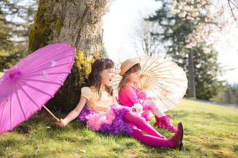 Two girls sit beneath a tree in springtime, Vancouver B.C.