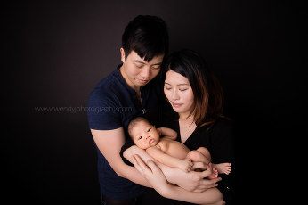 Vancouver newborn photography session, newborn girl held by her parents.