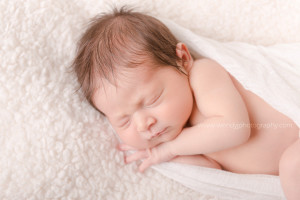 Close-up of a sleeping newborn baby girl., wrapped in white cloth.